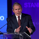 George W. Bush stands at a lectern with his hands in front of him